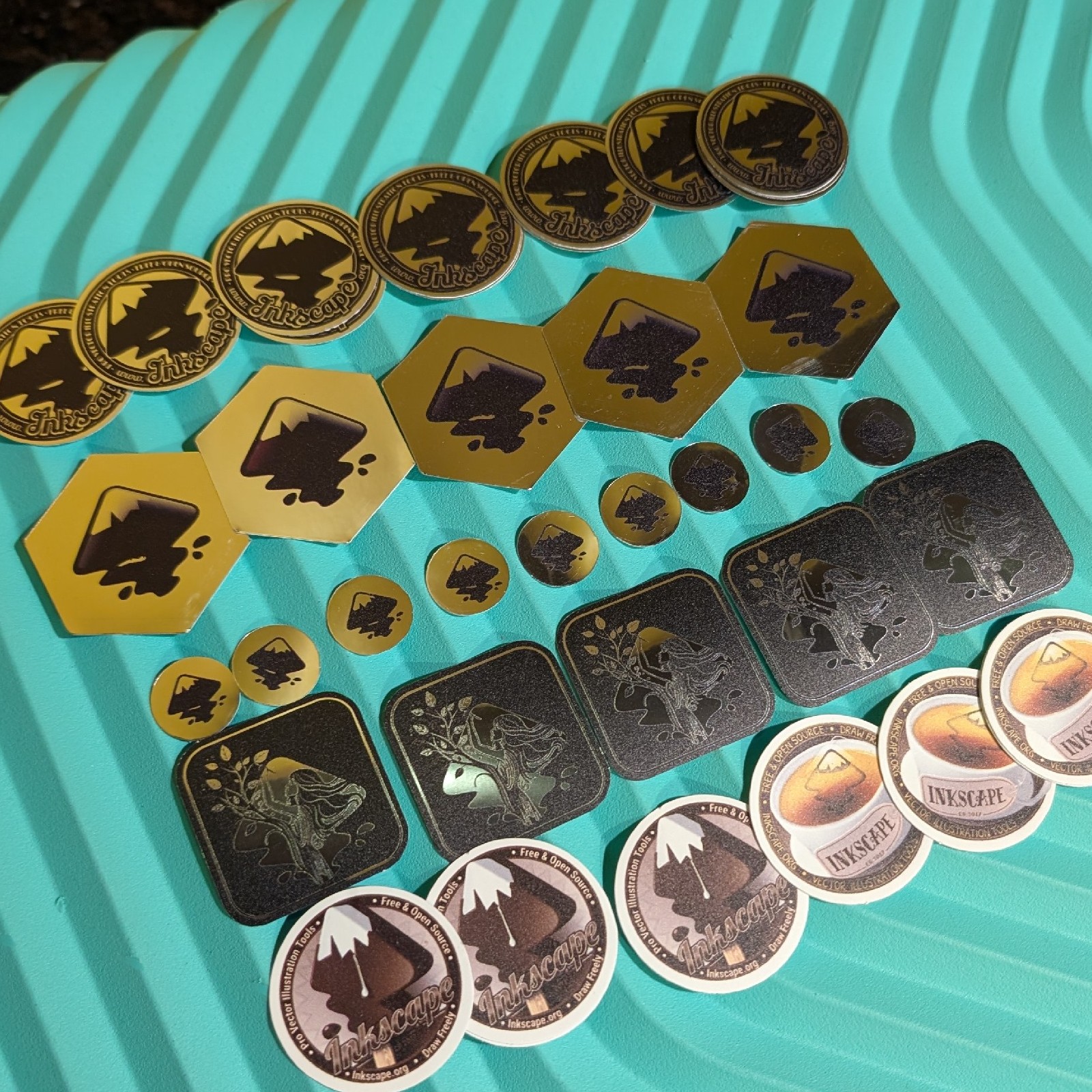 6 different designs of Inkscape stickers against a green background available at our booth.