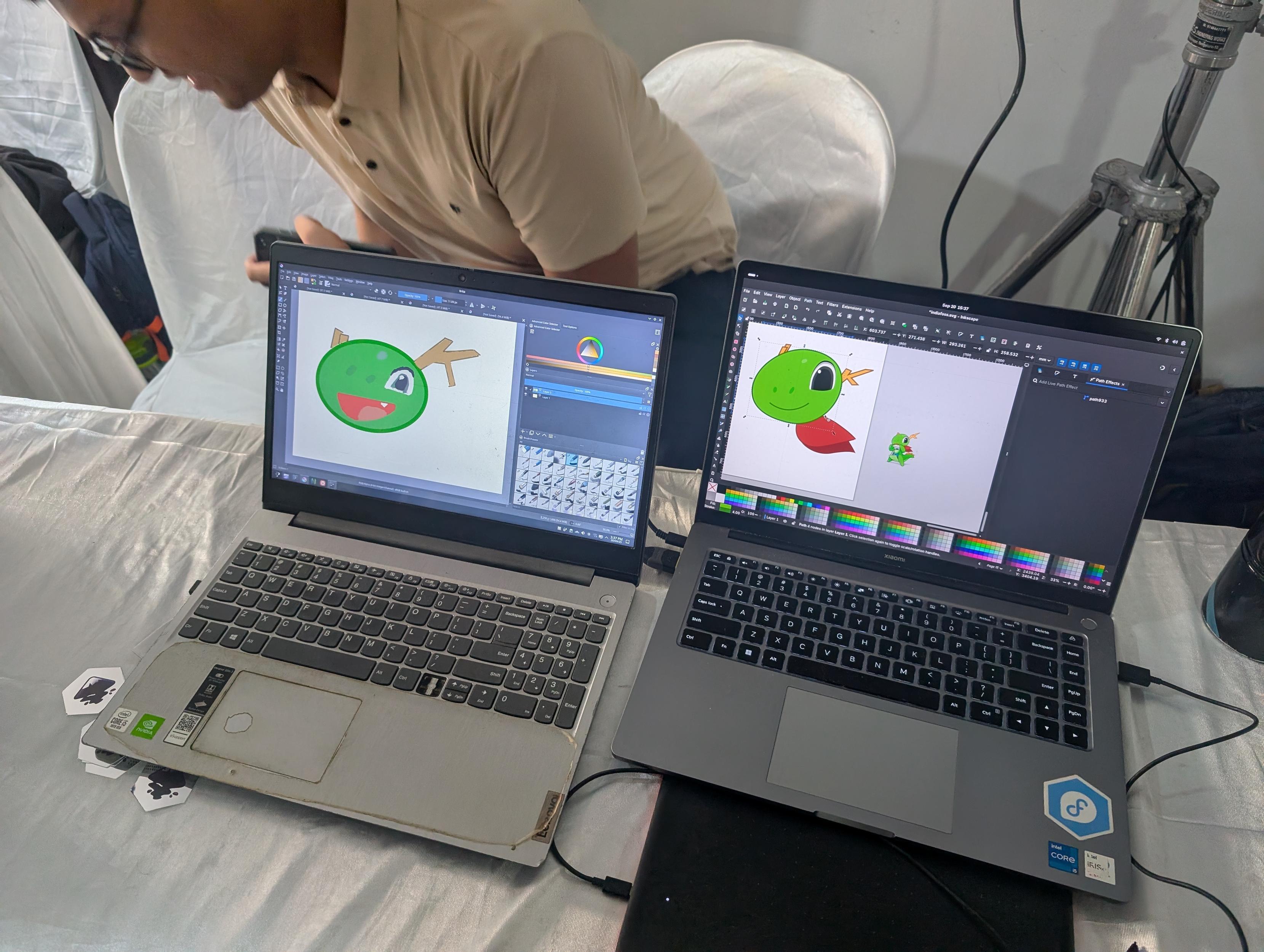 Two drawings of Konqi (the mascot of KDE) on two different laptops. The left one is drawn in Krita, the right one is drawn in Inkscape.